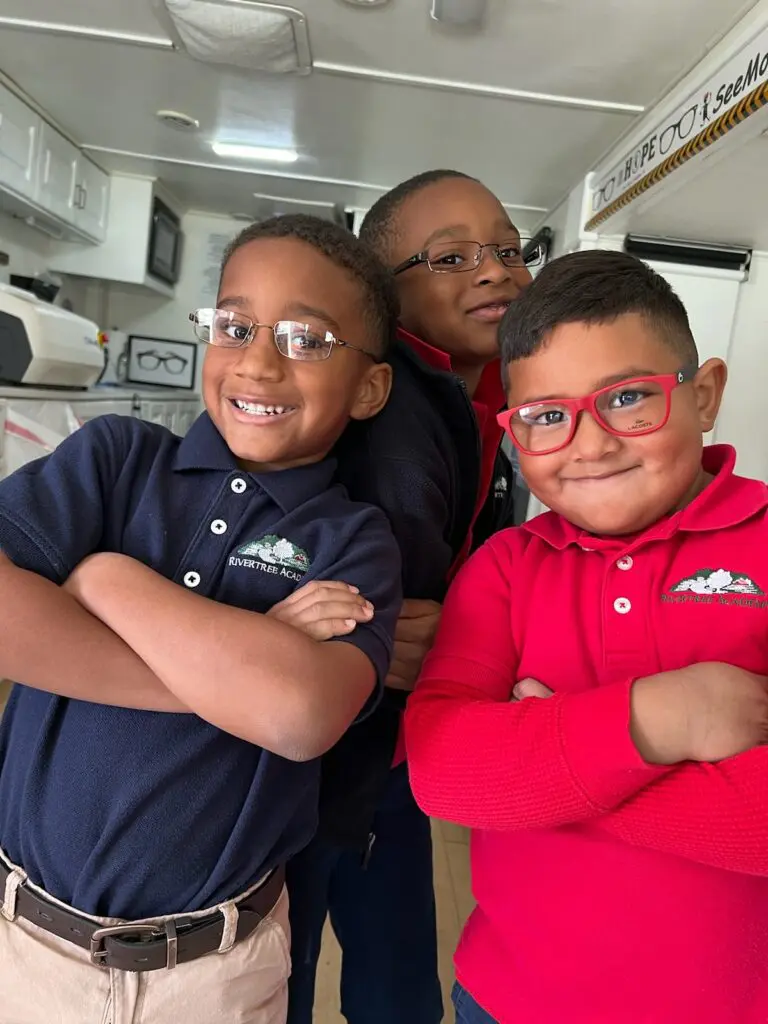 A woman and two boys wearing glasses posing for the camera.